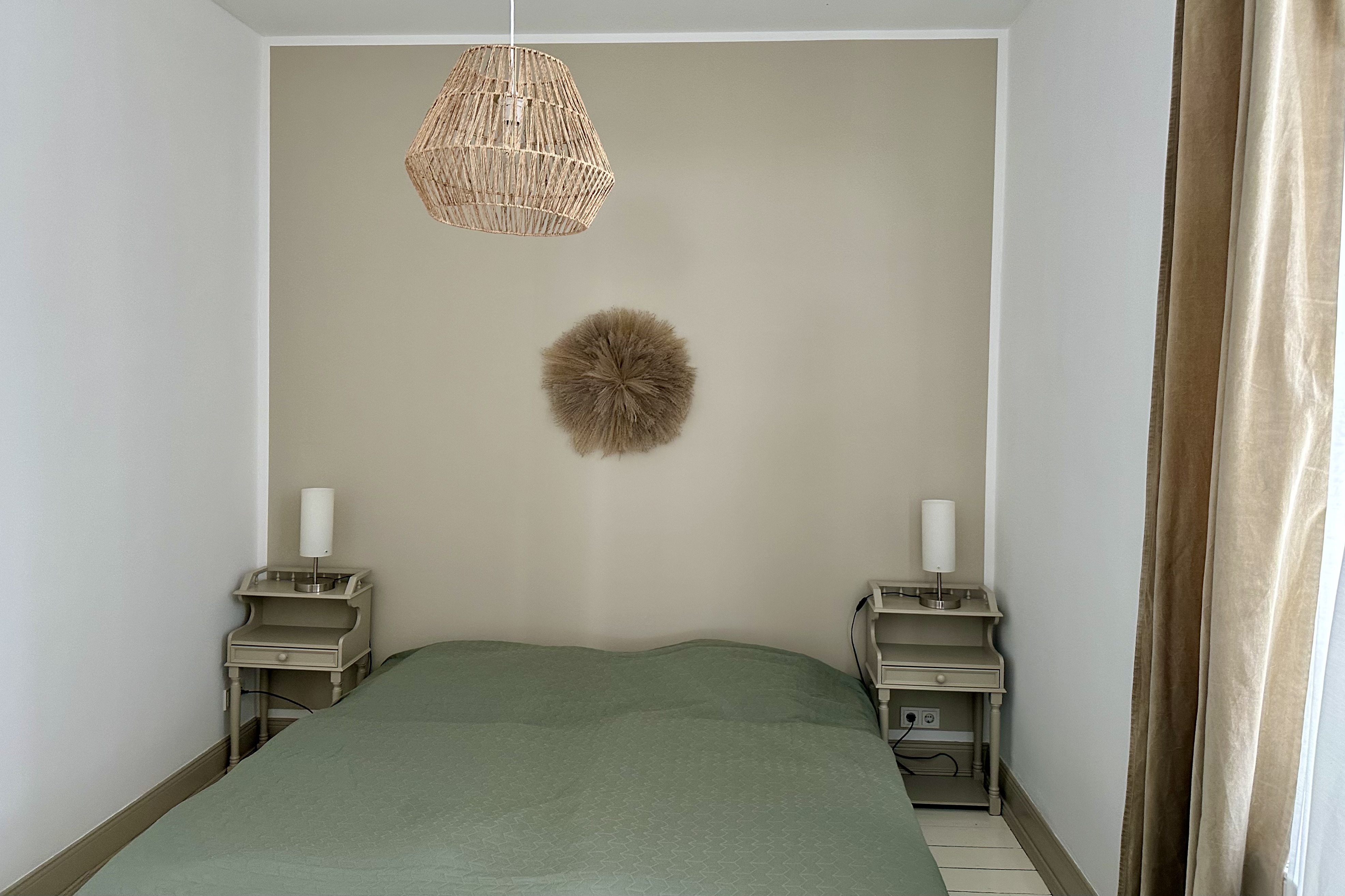 ein Schlafzimmer mit Doppelbett, daneben zwei antike Nachttische